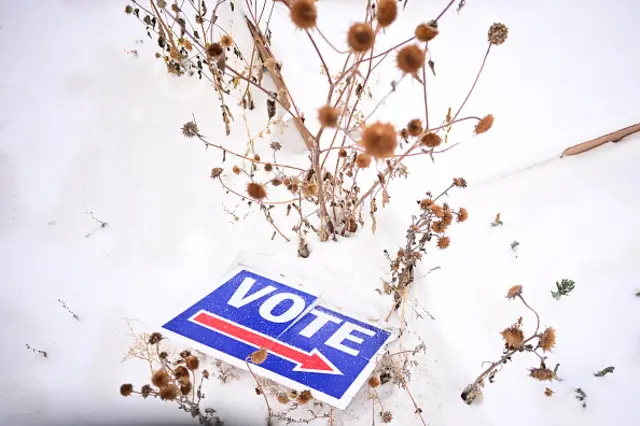 A "vote" sign is covered in snow outside the Nederland Community Centre polling location in Colorado