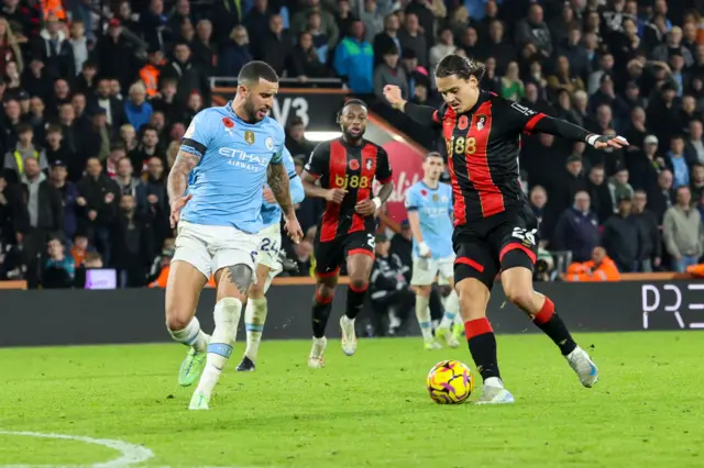 Kyle Walker challenges Enes Unal of Bournemouth