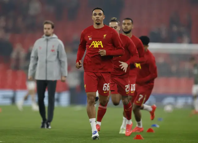 Alexander-Arnold runs at the front of a queue in the warm up