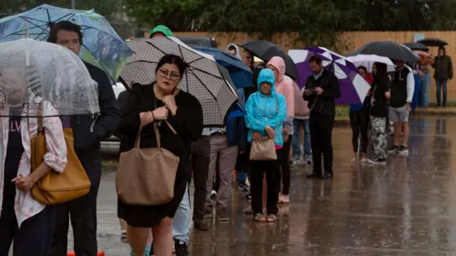 Despite heavy rain, people wait in line to vote at the Metropolitan Multi-Service Center on November 5, 2024 in Houston, Texas.