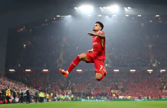 Diaz jumps into the air and pumps his fist to celebrate his hat-trick goal