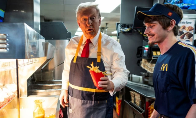 Donald Trump holds a packet of McDonalds fries as he puts in a shift on the presidential campaign trail