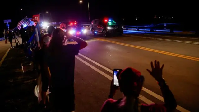 Supporters react as Republican presidential nominee and former U.S. President Donald Trump's motorcade passes by a bridge near Mar-a-Lago, in Palm Beach, Florida