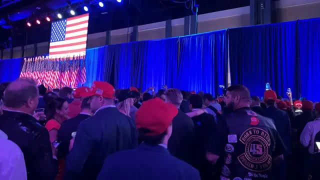 A view of the stage at Trump#s watch party, looking over the heads of supporters at the curtain over the stage