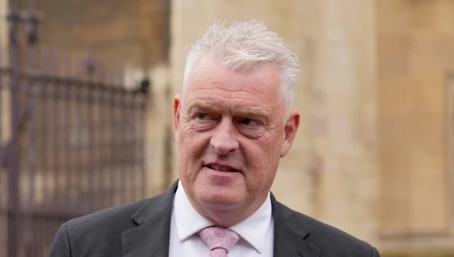 Reform UK MP Lee Anderson outside the House of Commons in Westminster. He wears a black suit, a white shirt and a pink tie.