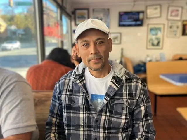 Jowan sitting in a diner wearing a checked shirt