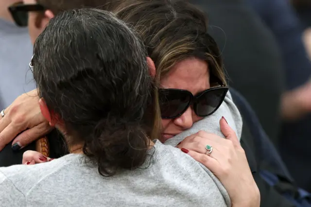 Two women console each other