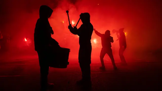 Hearts fans banging a drum in a pyro show