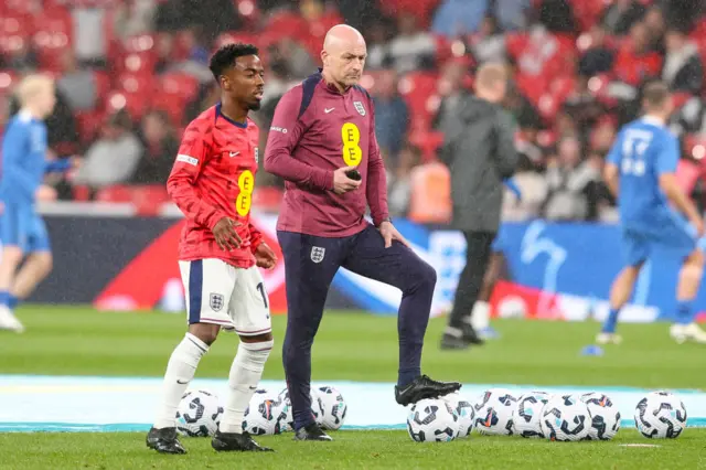 Head Coach Lee Carsley with Angel Gomes of England during warm up