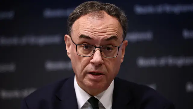 Bank of England governor Andrew Bailey wearing a dark blue suit, white shirt and black tie at a news conference