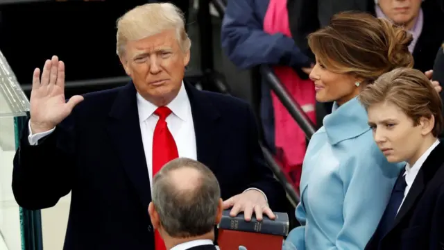 US President Donald Trump takes the oath of office with his wife Melania and son Barron at his side, during his inauguration at the U.S. Capitol in Washington