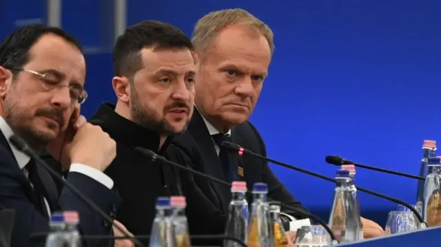 Ukraine leader Volodymyr Zelensky speaking at a summit in Budapest on 7 November 2024, with two men sitting either side