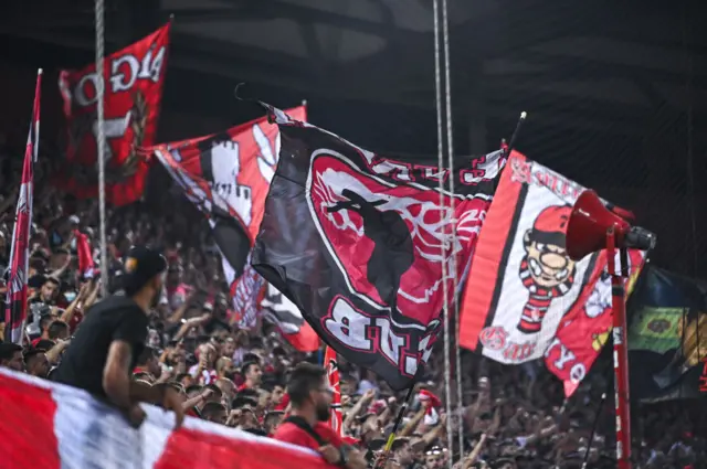 Supporters hold up banners at the Georgios Karaiskakis Stadium