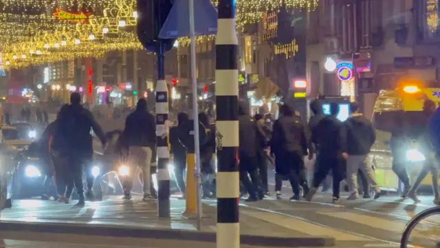 Screengrab of a social media video which reportedly shows clashes between the Israeli football supporters and Dutch youth, with a group of people standing in the middle of a busy road