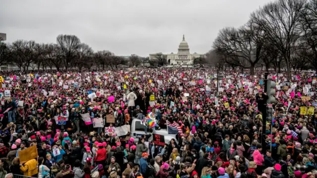 A sea of people holding signs in front of the Capitol