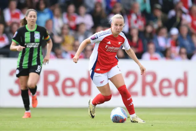 Beth Mead runs away with the ball as Vicky Losada watches on