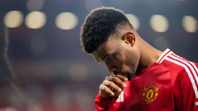 Manchester United's Amad Diallo puts his hand to his lips while looking deep in thought