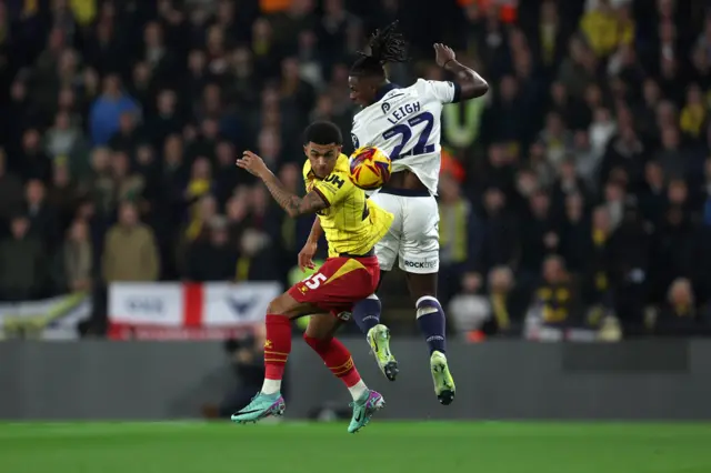 Ryan Andrews of Watford and Greg Leigh of Oxford United battle for the ball in the air