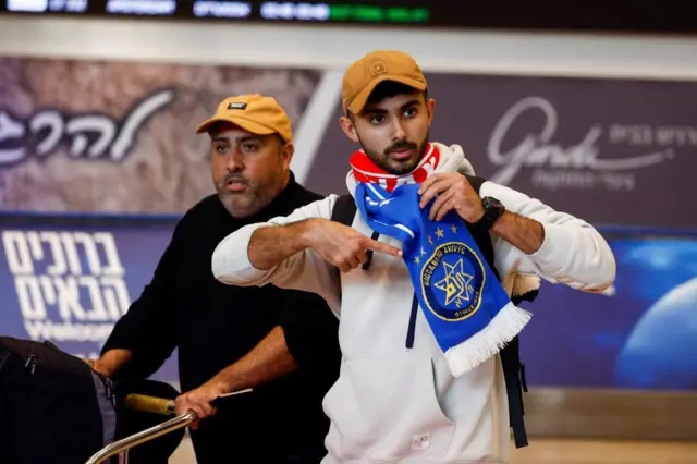 An Israeli Maccabi Tel Aviv soccer fan gestures as they arrive at the Ben Gurion International Airport, after overnight attacks after the match between Maccabi and Ajax Amsterdam