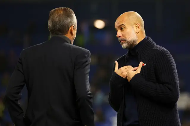 Guardiola chats to a member of his backroom team