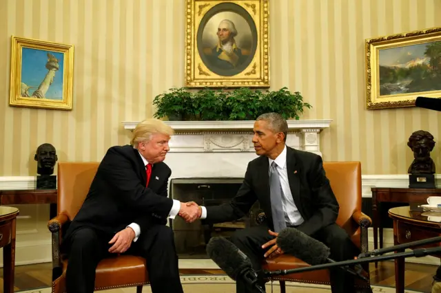 Donald Trump and Barak Obama shake hands in the Oval Office in 2016