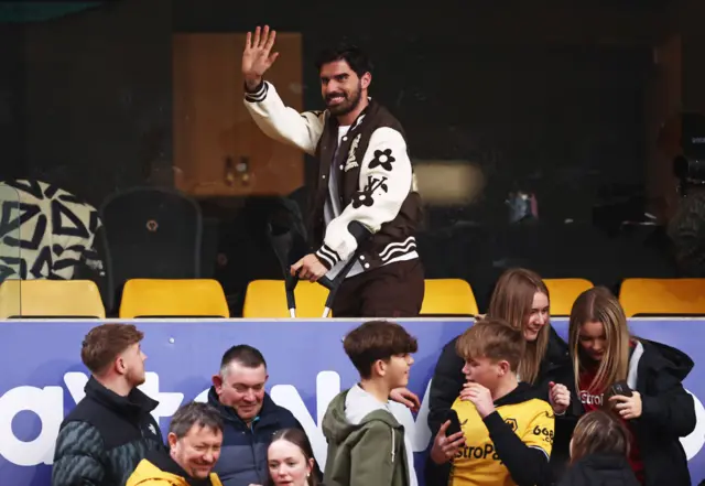 Ruben Neves waves to Wolves fans from a corporate box