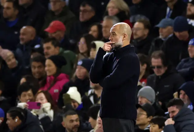 Guardiola watches on as he holds his chin in his hand