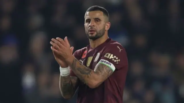 Man City defender Kyle Walker applauds travelling City fans.