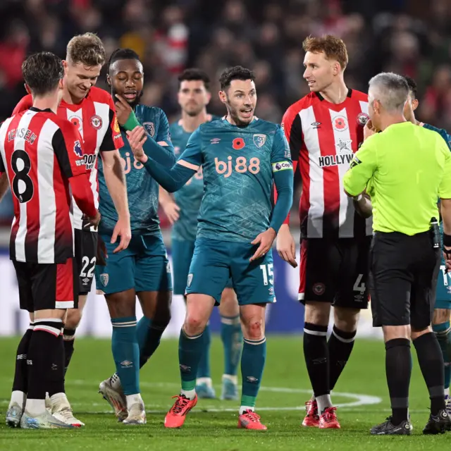 Bournemouth players surround referee Darren Bond.