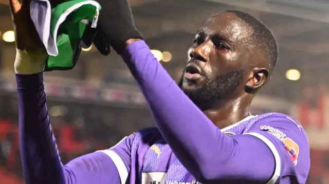 Alassana Jatta applauds the Notts County fans with a flag of The Gambia in his hands