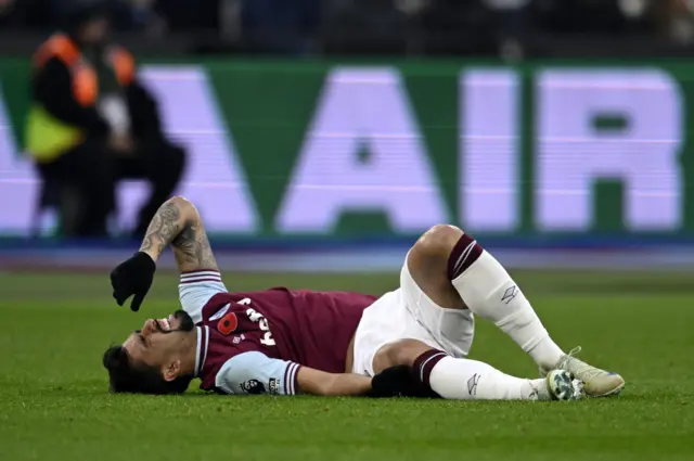 Paqueta lies on the floor holding his leg