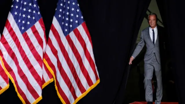 RFK stands in the background of American flags