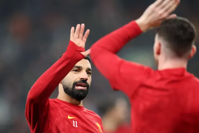 Salah high fives someone in the warm up