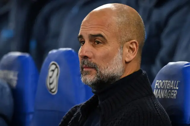 Pep Guardiola deep in thought on the bench