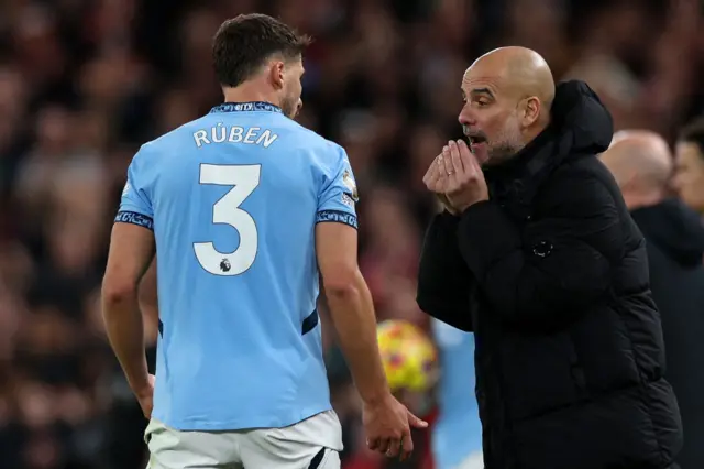 Pep Guardiola gestures to Ruben Dias