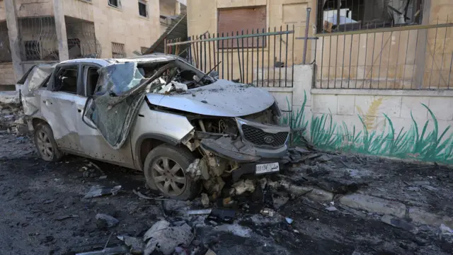 A damaged vehicle with rubble on the ground