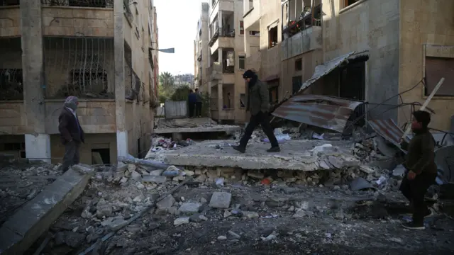 Civilians inspect the rubble following air strikes