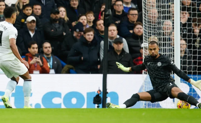 Robert Sanchez of Chelsea (R) saves a shot from Ollie Watkins