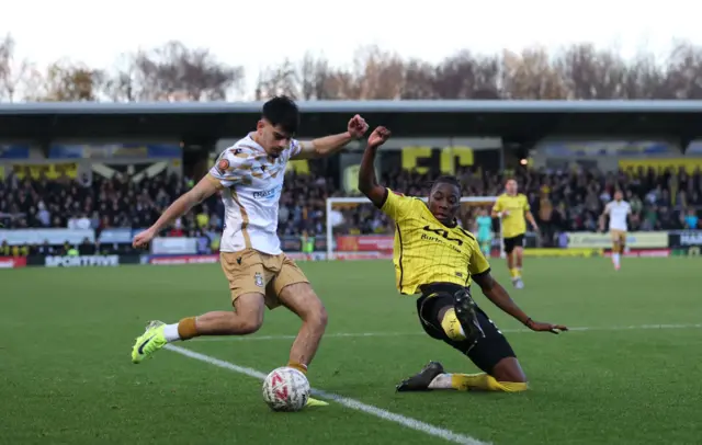 Ronan Maher of Tamworth is challenged by Kegs Chauke of Burton Albion