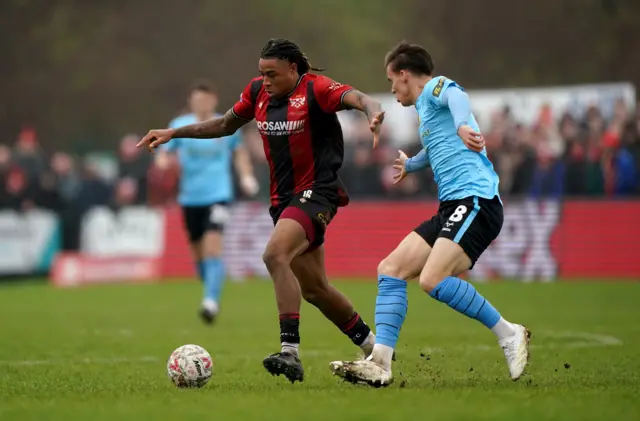 Kettering Town's Isiah Noel-Williams battles for the ball against Doncaster Rovers' George Broadbent