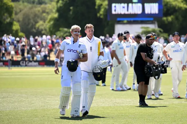 Jacon Bethell and Joe Root walk off after guiding Englan to victory