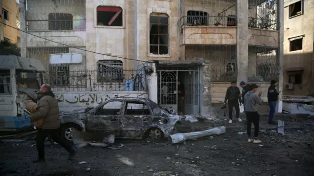 People inspect the damage after an airstrike in Idlib, northern Syria, 01 December 2024.