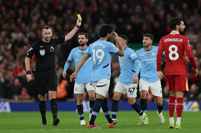 Chris Kavanagh shows a yellow card to Manchester City's English midfielder #47 Phil Foden.