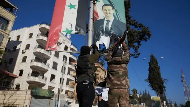 Syrian opposition fighters tear up a portrait of Syrian President Bashar al-Assad in central Aleppo, Syria