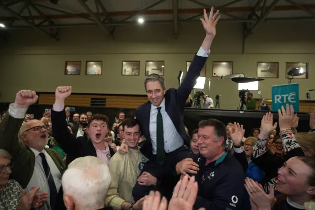 Simon Harris lifted up while celebrating win in count centre.