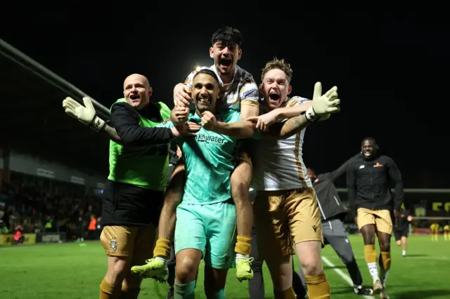 Goal scorer, Ronan Maher and Goal keeper, Jasbir Singh of Tamworth celebrate with teammates Tom Tonks and Daniel Creaney of Tamworth following the team's victory during the Emirates FA Cup Second Round match between Burton Albion and Tamworth