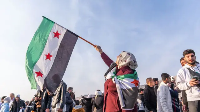 Syrians holding 'revolution flag' gather at Umayyad Square in Damascus to celebrate the collapse of 61 years of Baath Party rule