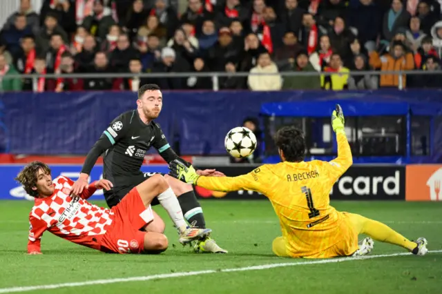 Andrew Robertson and Liverpool's Brazilian goalkeeper #01 Alisson Becker vie for the ball