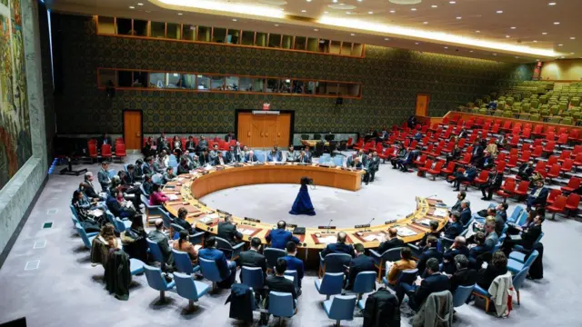 A UN Security Council meeting showing a round table with diplomats and representatives sat around it.