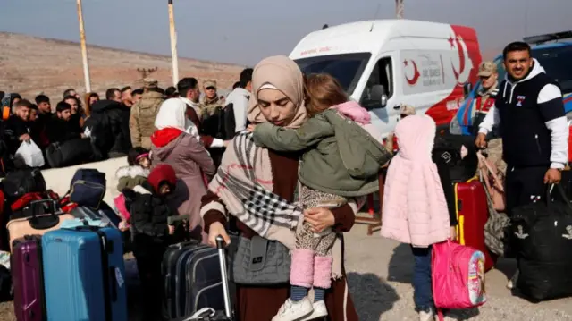 Syrian migrants wait at the Cilvegozu border gate to cross into Syria, after Syrian rebels announced that they have ousted Syria's Bashar al-Assad, in the Turkish town of Reyhanli in Hatay province, Turkey, December 10, 2024.